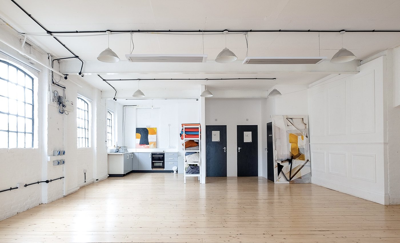 Open studio with kitchen area and art on walls